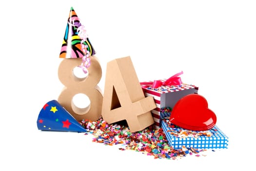 Number of age in a colorful studio setting with paper party hats, a red heart and gifts on a bottom of confettie