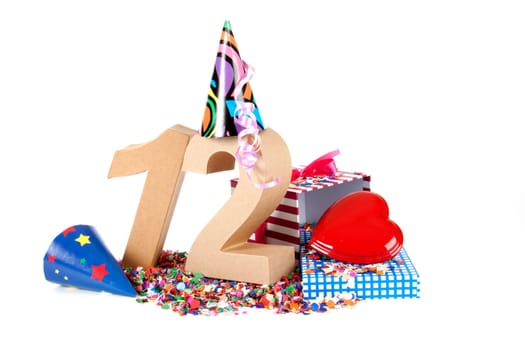 Number of age in a colorful studio setting with paper party hats, a red heart and gifts on a bottom of confettie