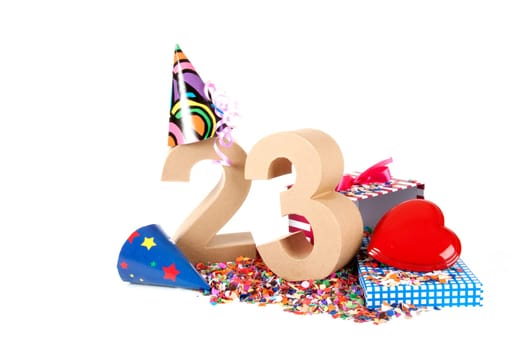 Number of age in a colorful studio setting with paper party hats, a red heart and gifts on a bottom of confettie
