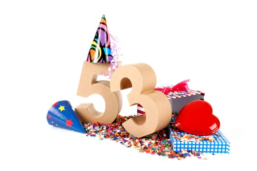 Number of age in a colorful studio setting with paper party hats, a red heart and gifts on a bottom of confettie