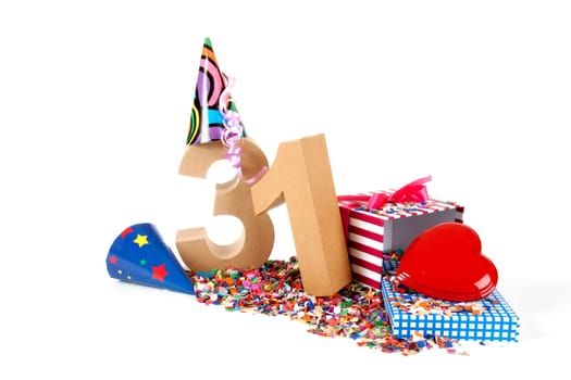 Number of age in a colorful studio setting with paper party hats, a red heart and gifts on a bottom of confettie