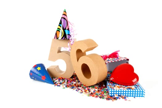 Number of age in a colorful studio setting with paper party hats, a red heart and gifts on a bottom of confettie