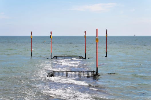 Poles with warning signs in the sea
