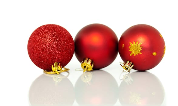 Red Christmas tree baubles decorations at xmas on white background with reflection