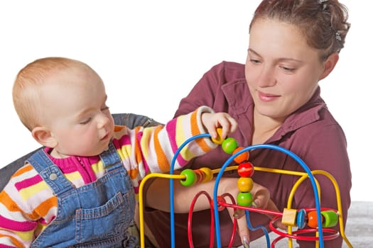 Baby with motor activity development delay being stimulated to develop muscle coordination and movement on a bead maze watched by a devoted mother