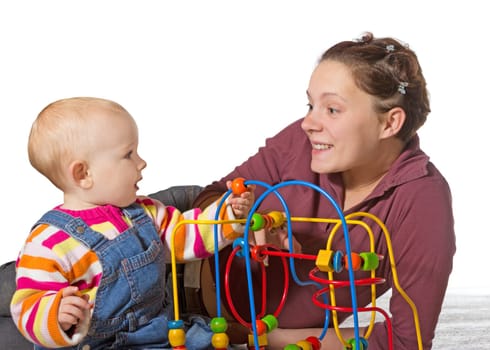 Baby with motor activity development delay being stimulated to develop coordination and muscle control and movement on a bead maze by an adoring mother