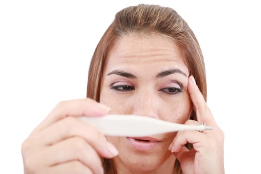 Sick woman looking at a clinical thermometer
