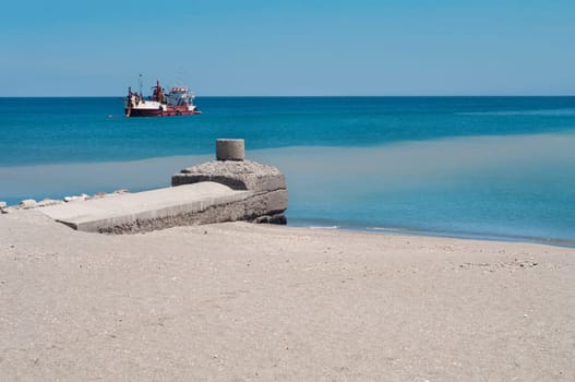 Pier and ship, blue sea and sand