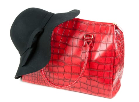 Red Fashion ladies handbag and a black felt hat in the studio on a white background