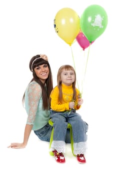 Mother and his daughters with colorful balloons. studio shoot over white background