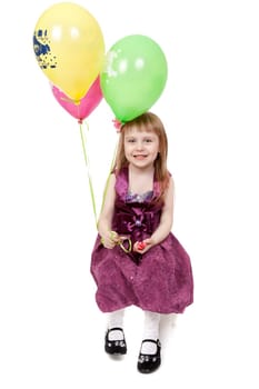 A laughing kid in red dress is playing with balloons  isolated on the white background