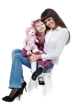 Mother and daughter sitting on a chair in the studio on a white background