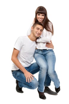 beautiful young couple sitting on the floor abd smiling isolated on a white background