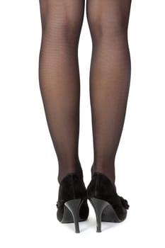 A womans legs with high heel shoes on a white background.