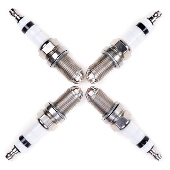 Set of four spark plugs arranged in a cross on a white background