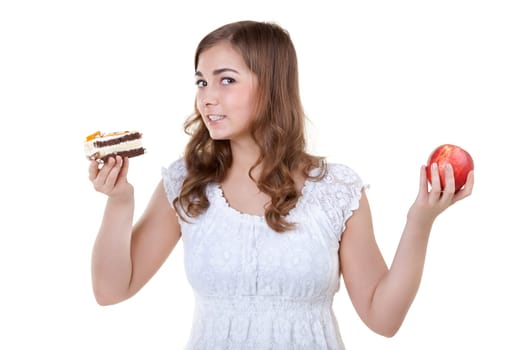 Young beautiful woman choose from sweet cake and red apple