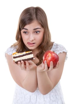 Young beautiful female choose from sweet cake and red apple, on white background