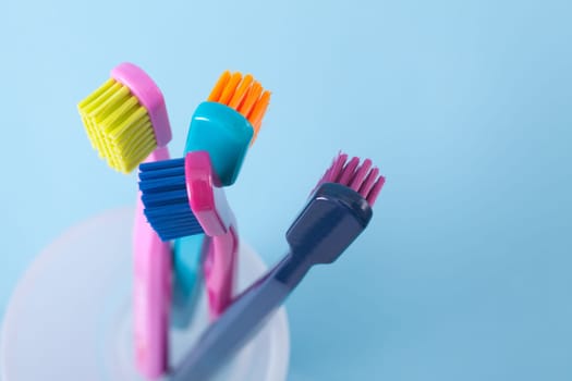 Four toothbrushes - dental hygiene. Top view, selective focused on top of right toothbrush, blue background.