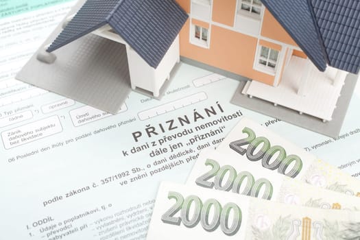 Czech property transfer tax form, model of the house and Czech money.