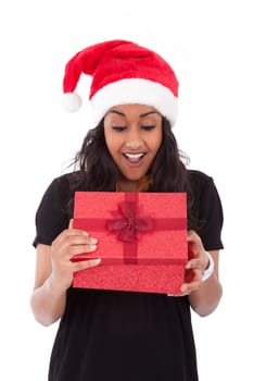 Young African American woman wearing a santa hat opening a gift box, isolated on white background