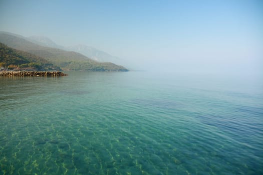 blue sky and light green sea with smoke