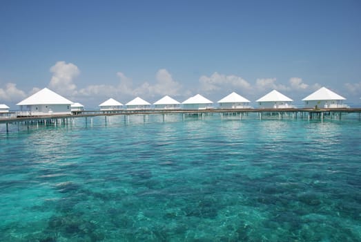 Clear turquoise waters with water bungalow Maldives