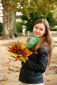 beautiful girl portrait while hoilding leaf bouquet in park