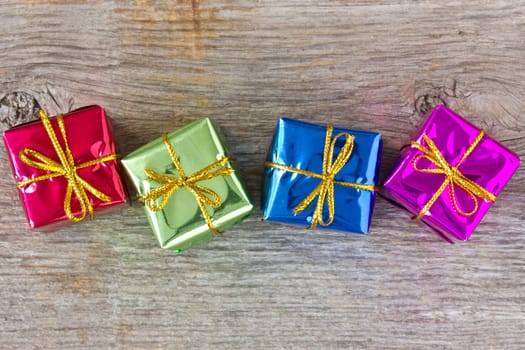 Four colorful gift boxes on the wooden floor