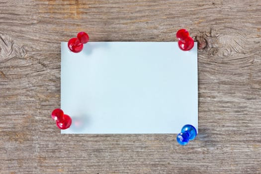 Blue sheet of paper for note and pushpins on the board