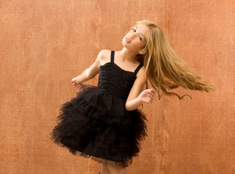 black dress kid girl dancing and twisting on vintage background