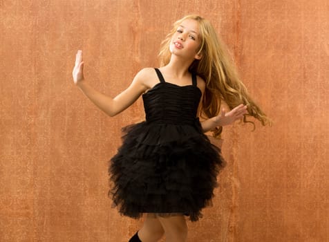 black dress kid girl dancing and twisting on vintage background