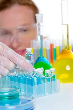 chemical laboratory scientist woman working with glass blue bottles
