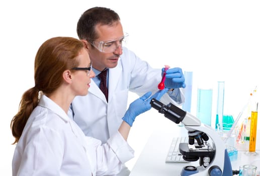laboratory with two scientist working with test tubes flask and microscope