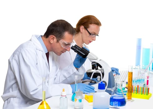 laboratory with two scientist working with test tubes flask and microscope