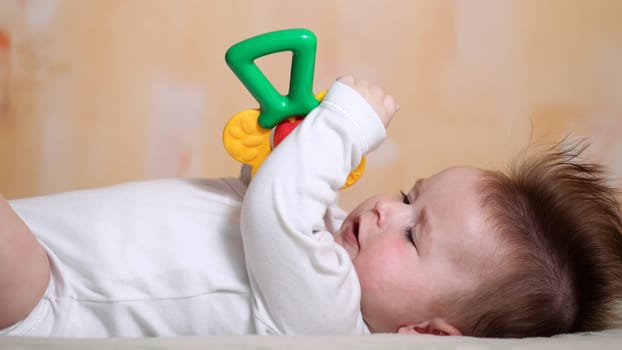 Portrait of a playing baby lying down on back