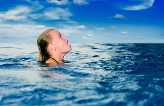 cute preteen in the ocean looking up with mouth wide open