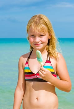 Young girl eating an ice cream at the beach