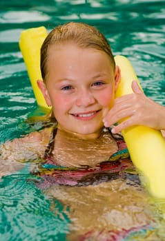 cute preteen in the water with a styrofoam noodle