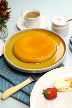 Creme caramel dessert ready to be served with coffee, strawberries and cream.