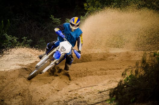 Enduro bike rider on action. Turn on sand terrain.