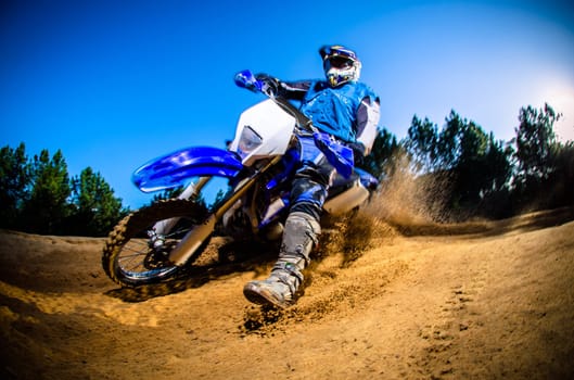 Enduro bike rider on action. Turn on sand terrain.