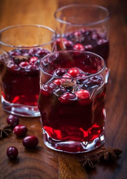 Hot drink with cranberries for Christmas on wooden table
