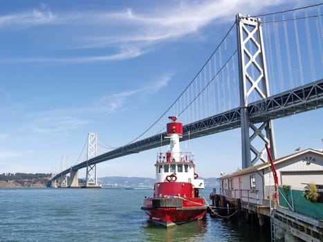 San Francisco Bay Bridge with a red ship
