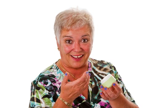 Senior woman applying cream - isolated on white background