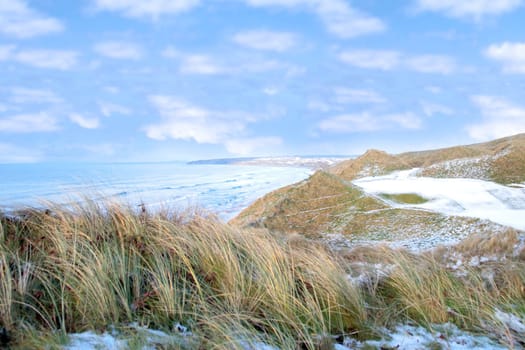atlantic ocean beside a snow covered links golf course in ireland in snowy winter weather