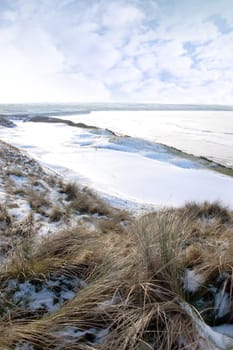 atlantic ocean beside a snow covered links golf course in ireland in snowy winter weather