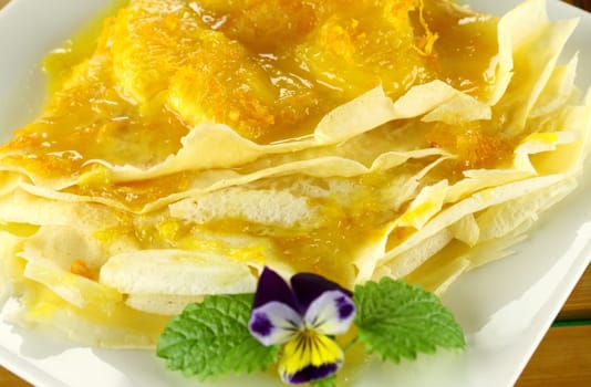 Delicious orange crepes with citrus ice cream and custard creme.