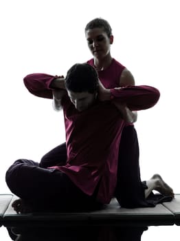 one man and woman perfoming thai massage in silhouette studio on white background