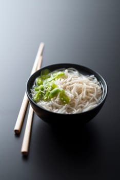 Chinese soup with noodles spring onion and sesame close up