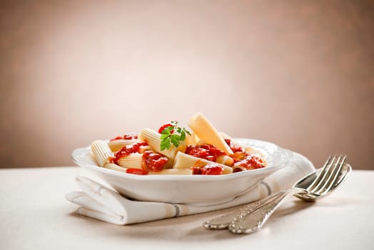 Fresh macaroni pasta with tomato sauce close up